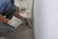 Worker plastering wall with putty knife indoors, closeup. Space for text Royalty Free Stock Photo