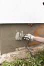 A worker plasters the foundation with cement plaster and glues in the mesh. Royalty Free Stock Photo