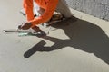 Worker plasters the wet cement concrete floor using a trowel after pouring the concrete in floor Royalty Free Stock Photo