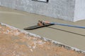 Worker plasters a wet concrete floor using a trowel after pouring concrete on surface Royalty Free Stock Photo