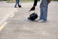 Worker is pouring asphalt for road repair