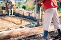 Worker pouring concrete or cement with automatic pump on construction site. Industrial details Royalty Free Stock Photo