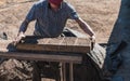 Worker pours the mixture of mud, sand and sawdust over molds for making bricks Royalty Free Stock Photo