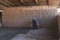 Worker pours the mixture of mud, sand and sawdust over molds for making bricks Royalty Free Stock Photo