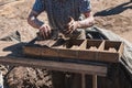 Worker pours the mixture of mud, sand and sawdust over molds for making bricks Royalty Free Stock Photo