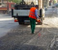 Worker pours water on the milled asphalt