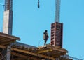 A worker prepares formwork for a modern metal-concrete structure of a residential building