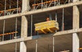 A worker prepares formwork for a modern metal-concrete structure of a residential building