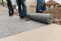 Worker prepares geotextile for the roof, covers it with synthetic membrane