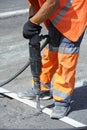 Worker preparing lay for asphalting the road on the street using pneumatic road breaker