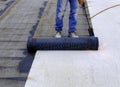 Worker preparing part of bitumen roofing felt roll for Royalty Free Stock Photo