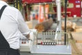 Worker pressing buttons on CNC machine control board in factory. Partially milled log on a portable lumber milling machine. Royalty Free Stock Photo