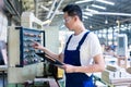 Worker pressing buttons on CNC machine in factory Royalty Free Stock Photo