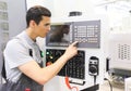 Worker pressing buttons on CNC machine Royalty Free Stock Photo