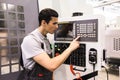 Worker pressing buttons on CNC machine Royalty Free Stock Photo