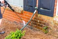 Person cleaning brick wall with pressure washer Royalty Free Stock Photo