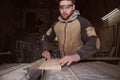 A worker processes a Board on a woodworking machine Royalty Free Stock Photo