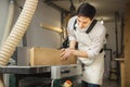 Worker processes board on woodworking machine Royalty Free Stock Photo