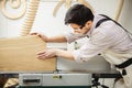 Worker processes board on woodworking machine Royalty Free Stock Photo