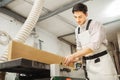 Worker processes board on woodworking machine