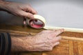 Worker protecting batten moulding with masking tape before paint