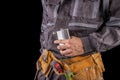A worker in protective clothing and a flask with vodka. Drunk production worker in the workplace Royalty Free Stock Photo