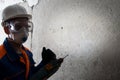 Worker in protective clothing, mask and hard hat , engaged in dismantling concrete walls , drill, there is a place for the