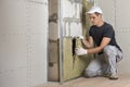 Worker in protective gloves insulating rock wool insulation in wooden frame for future house walls for cold barrier. Comfortable Royalty Free Stock Photo