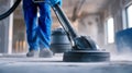 Worker in protective gloves and uniform using professional floor cleaning machine to remove dust and dirt from industrial concrete Royalty Free Stock Photo