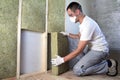 Worker in protective goggles and respirator insulating rock wool insulation in wooden frame for future house walls for cold Royalty Free Stock Photo