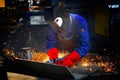 Worker with protective mask and gloves grinding/we