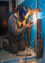 Worker welding a metal door. Royalty Free Stock Photo