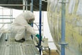 Worker in protective suit completes maintenance on aircraft fuselage during restoration at an aerospace facility in a controlled Royalty Free Stock Photo