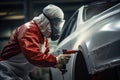 Worker in protective suit and mask polishing car body at car service station, Car painter in protective clothes and mask painting Royalty Free Stock Photo