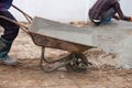 Worker pushing barrow with wet cement to pouring concrete floor Royalty Free Stock Photo