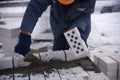 A worker puts bricks in cement in straight rows, makes a concrete wall. Royalty Free Stock Photo