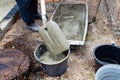 worker puts concrete in bucket with shovel Royalty Free Stock Photo