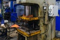 Worker puts iron hot part into press for pressing and quenching Royalty Free Stock Photo
