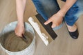 Worker puts plaster on a spatula from a bucket