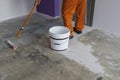 Worker puts primer with roller on concrete floor Royalty Free Stock Photo