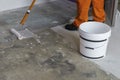 Worker puts primer with roller on concrete floor. House under co Royalty Free Stock Photo