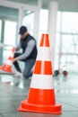 worker putting cones around area wetness on tiled floor