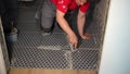 Worker putting fugue on floor in bathroom. Grouting ceramic tiles