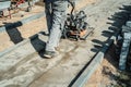 Worker rams the ground with a vibrating machine. Top view