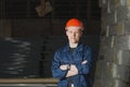 Worker in a red cap stands against the backdrop of the warehouse Royalty Free Stock Photo