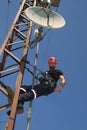 Worker in red helmet working on radio link antenna system