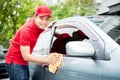 Worker in red uniform cleaning car