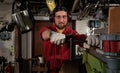 Worker in red uniform operating in manual lathe in metal big workshop Royalty Free Stock Photo