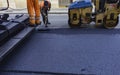 Worker regulate tracked paver laying asphalt Royalty Free Stock Photo