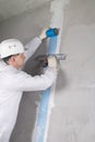 a worker reinforces the cracked wall with mesh